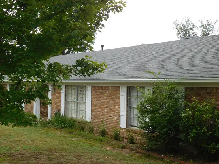 Roof replacement with gray architectural shingles on a brick home in Tyler
